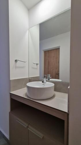 y baño con lavabo blanco y espejo. en Victor Hotel en Villa Carlos Paz