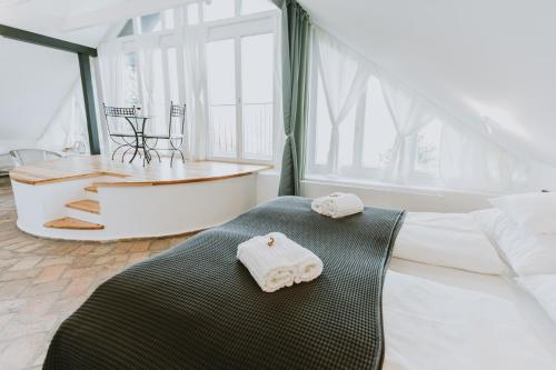 1 dormitorio con bañera y 2 toallas en una cama en Villa Mimi en Sopron