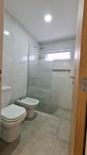 a bathroom with a toilet and a glass shower at Victor Hotel in Villa Carlos Paz