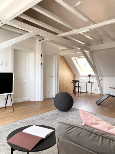 a living room with a couch and a tv at Zehuus mit Domblick und Dachterrasse in Cologne