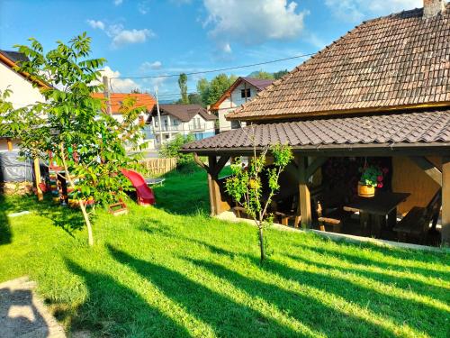 um quintal com um gazebo e algumas árvores em Vila Noris em Borşa