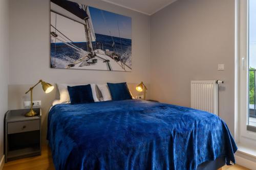 a bedroom with a bed with a blue blanket at Niebieski Horyzont in Jastrzębia Góra