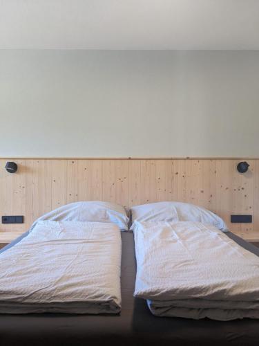 a bed with white sheets and pillows on it at Appartements Amber in Kleinarl