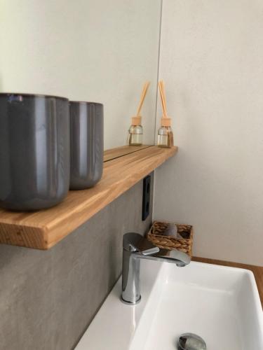 a bathroom sink with two large metal pots on a shelf at Appartements Amber in Kleinarl