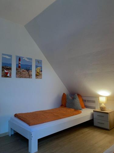 a white bedroom with a bed and a table at Ferienwohnung Jägerstüble in Deggenhausertal