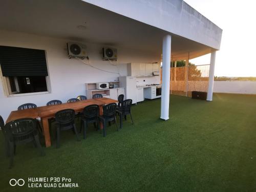 een eetkamer met een tafel en stoelen op een gazon bij Residence IL CARRUBO in Gallipoli