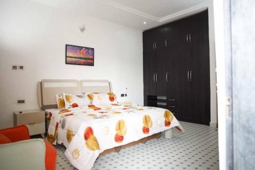 a bedroom with a large bed and a black cabinet at DMK Apartments in Abuja