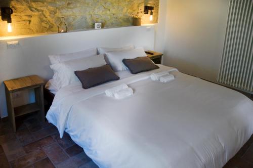 a bedroom with a white bed with two pillows at Le Dune rooms in Cinigiano