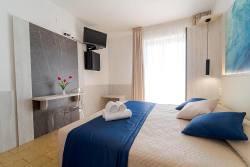 a bedroom with a blue bed with two white towels at Hotel Beach in Tortoreto Lido