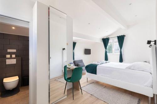 une chambre avec un lit blanc et une chaise verte dans l'établissement Maison moderne avec jardin12 pers proche Paris & Disney, à Neuilly-sur-Marne