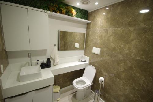 uma casa de banho com um WC branco e um lavatório. em Apto In Mare Bali 2 qts em Parnamirim
