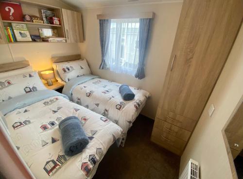 two beds in a small room with at Gannets Rest - Spacious Static Caravan with Sea Views in Polperro