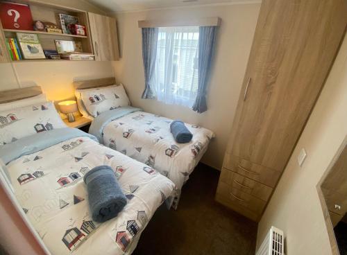 Dos camas en una habitación pequeña con en Gannets Rest - Spacious Static Caravan with Sea Views, en Polperro