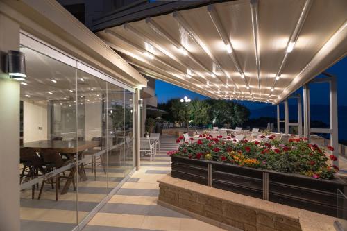 a patio with a table and flowers on it at Molos Bay Hotel in Kissamos