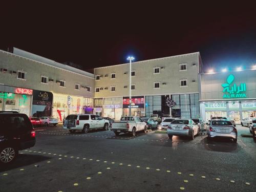 un estacionamiento con autos estacionados frente a un edificio en Safa PARK HOTEL YANBU فندق صفا بارك ينبع, en Yanbu