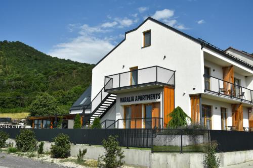 una casa blanca con una colina en el fondo en Varalja Apartments, en Plavecké Podhradie