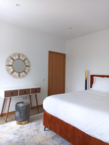 a bedroom with a bed and a table with a mirror at FAMILY APARTAMENT II in Coimbra