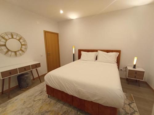 a bedroom with a large bed and a mirror at FAMILY APARTAMENT II in Coimbra