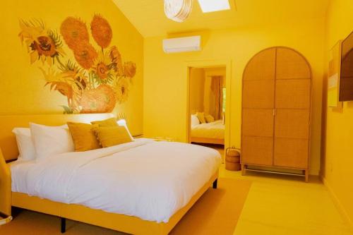 a bedroom with a large white bed with yellow walls at The Norsdale plus CMYK Motel on 10 acres in Phoenicia in Phoenicia