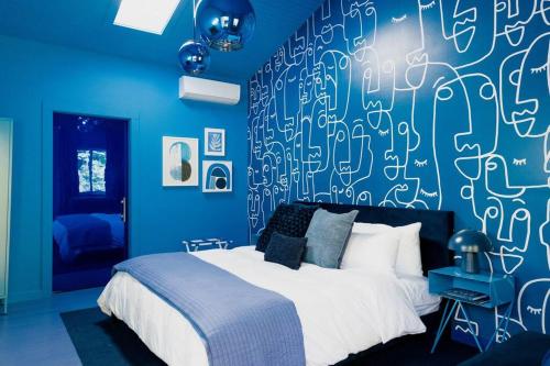 a blue bedroom with a bed with a blue wall at The Norsdale plus CMYK Motel on 10 acres in Phoenicia in Phoenicia