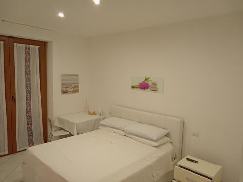 サン・ベネデット・デル・トロントにあるCasa Valentinaの白いベッドルーム(ベッド2台、椅子付)