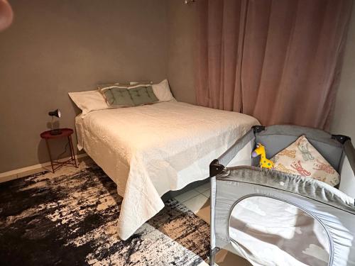 a small bedroom with a bed and a crib at WeMukelekile (you are welcome) in Lobamba