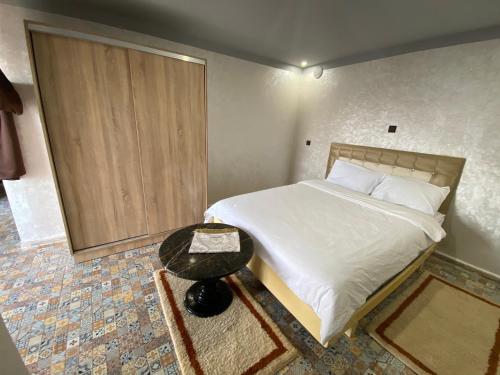 a small bedroom with a bed and a table at Hébergement dakhla plaisance in Dakhla