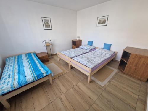 two beds in a room with wooden floors at Hannibal in Bulhary