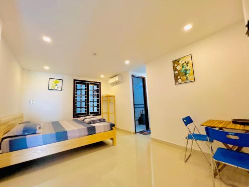 a bedroom with a bed and a table and chairs at Kenpi Homestay in Hue