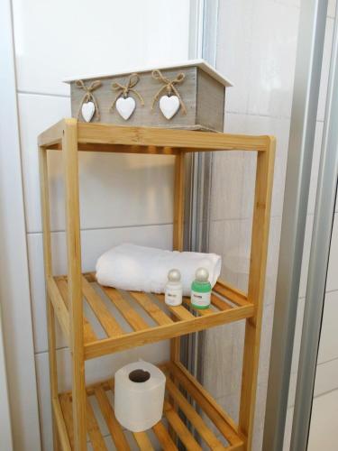 a wooden shelf with towels and a toilet paper at Hotel Gleis 3viertel Jena in Jena