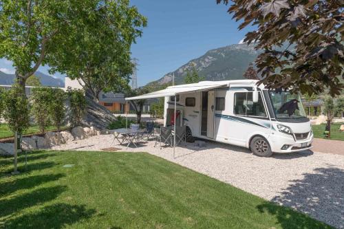 uma carrinha branca estacionada num parque de estacionamento em Camping Agrisalus em Arco