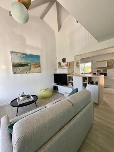 un salon avec un canapé et une table dans l'établissement La Villa Louca - Charme, Soleil & Détente aux Portes des Landes, à Saint-Vincent-de-Tyrosse