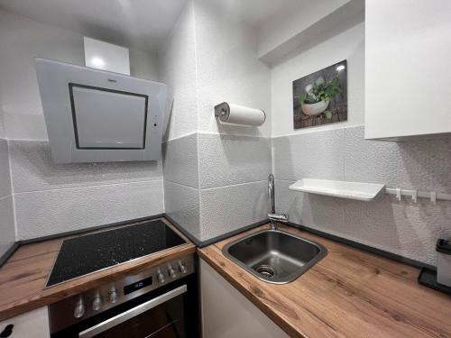 a small kitchen with a sink and a tv at Am Berg in Feldberg