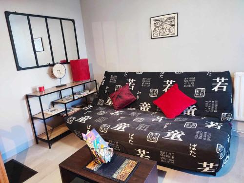 - un salon avec un canapé et un lit avec des oreillers dans l'établissement FUTUROGITE, à Saint-Georges-lès-Baillargeaux