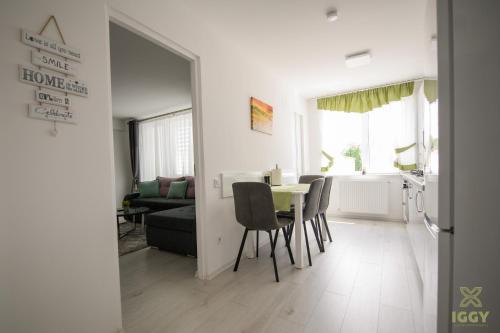 un soggiorno con tavolo e sedie e una cucina di Iggy Luxury Central Apartment a Hunedoara