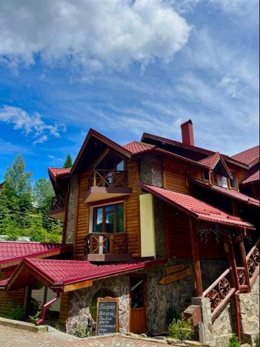 a large wooden building with red roof at Girskiy Prutets in Bukovel