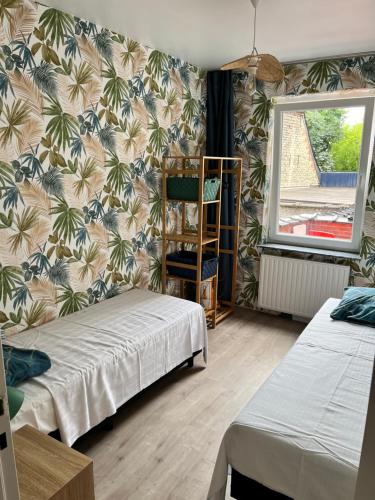 a room with two beds and a wall covered in wallpaper at Vilvoorde city center in Vilvoorde