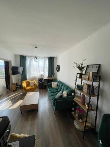 a living room with a green couch and a table at 1-izbový byt in Košice
