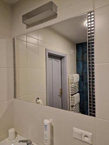 łazienka z dużym lustrem nad umywalką w obiekcie Hotel Podróżnik w mieście Koszuty