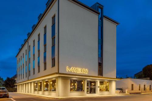 a large white building with a nike sign on it at Mayburg Salzburg, a Tribute Portfolio Hotel in Salzburg