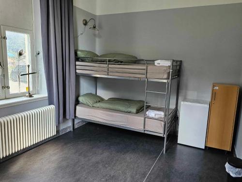 two bunk beds in a room with a window at Stora Ekeberg vandrarhem in Axvall