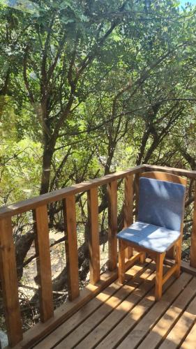 a blue chair sitting on a wooden deck at Reflections Camp in Faralya