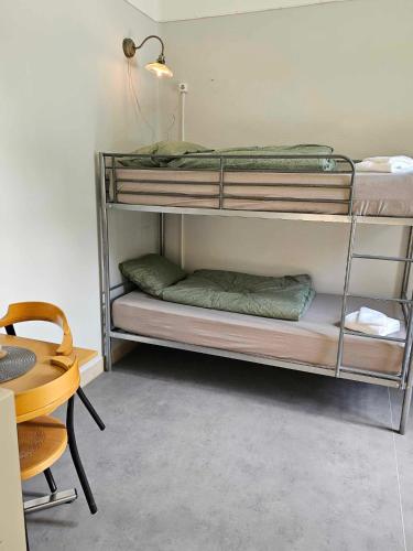 two bunk beds in a room with a table at Stora Ekeberg vandrarhem in Axvall
