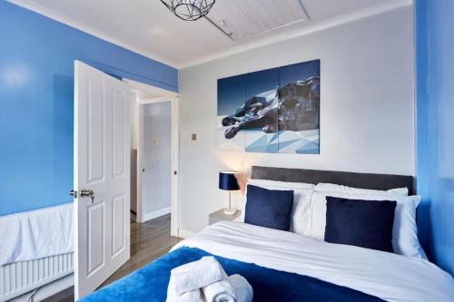 um quarto azul com uma cama grande e paredes azuis em *Little Haven in Leeds* ¤Private Parking¤ Ensuite em Killingbeck