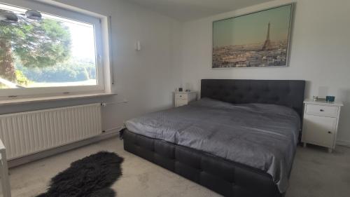 a bedroom with a bed and a large window at romantische Ferienwohnung im Vogelsbergkreis in Ehringshausen