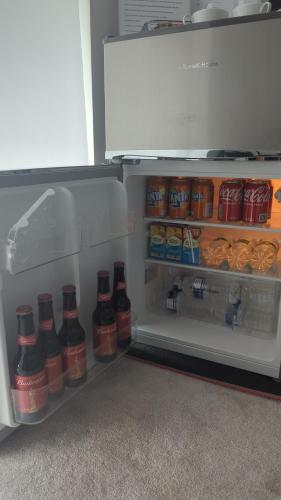 an open refrigerator filled with lots of drinks and food at Kingwood apartaments in London