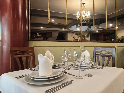 a dining table with a white table cloth and glasses at Faraona Grand Hotel in Lima