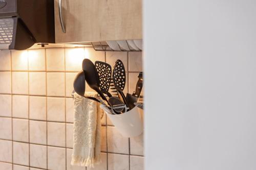 a rack of kitchen utensils hanging from a wall at The Olympus Garden Beach House in Litochoro