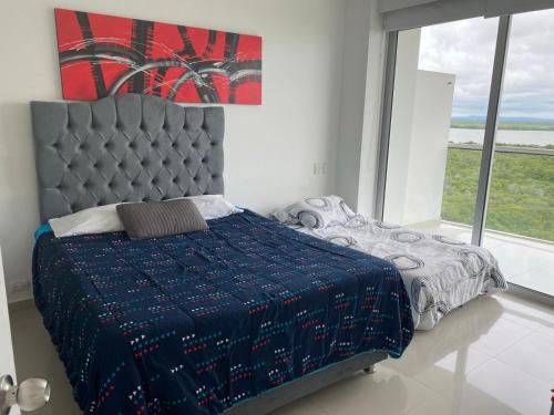 um quarto com uma cama e uma grande janela em Morros Epic piso 9 em Cartagena das Índias