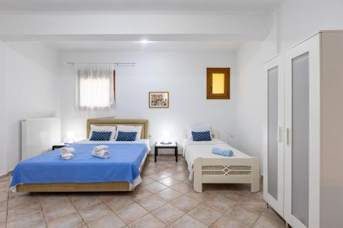 a bedroom with two beds with blue sheets at The Olympus Garden Beach House in Litochoro